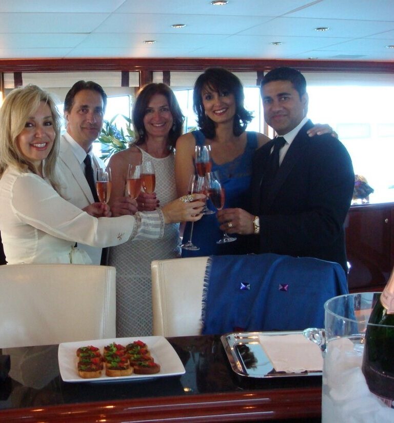 Jan Wallace, James Bianco, Sue Masterson, Afshan, and Amin Lahka — champagne toast aboard a yacht Jan Wallace, James Bianco, Sue Masterson, Afshan, and Amin Lahka — champagne toast aboard a yacht